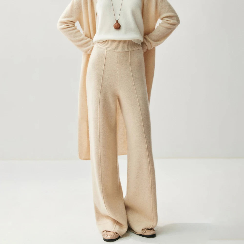 Beige high-waisted wide leg knitted pants with a center seam, paired with a matching long cardigan and white top.