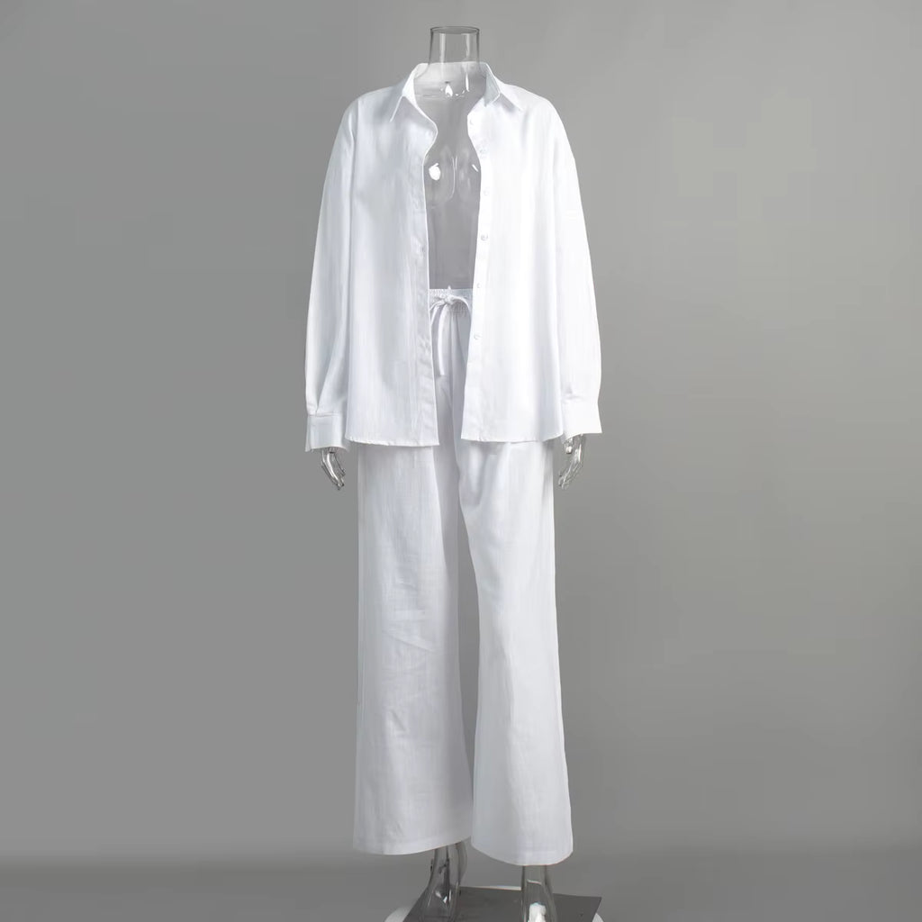 White long-sleeve button-down shirt and matching drawstring trousers on a clear mannequin.