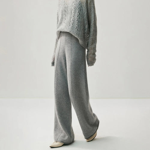 Grey knitted wide leg pants with a high waist and center seam detail, worn with a matching sweater and cream shoes.