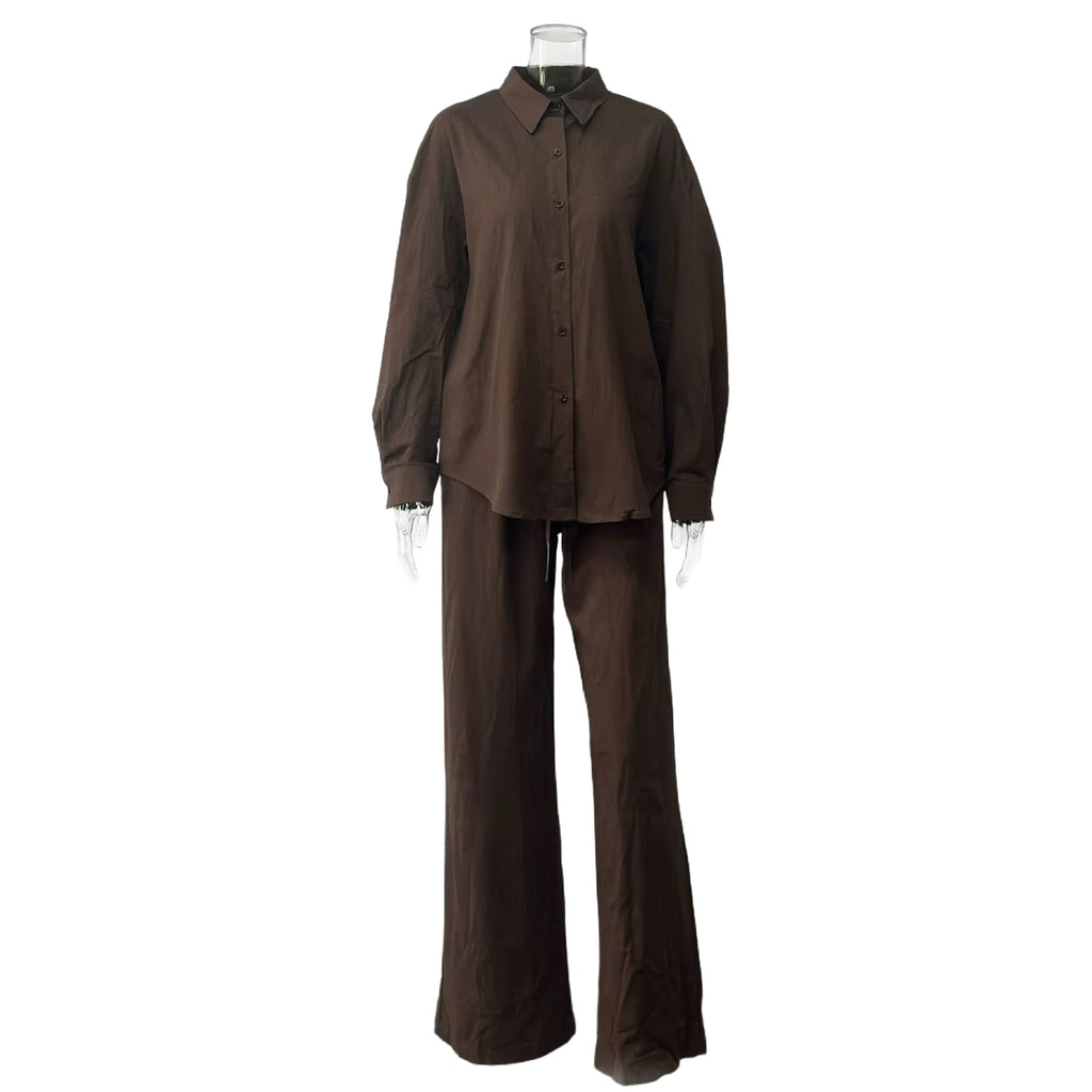 Brown two-piece fabric suit with a long-sleeve button-down shirt and matching wide-leg trousers on a clear mannequin.
