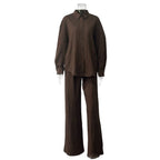 Brown two-piece fabric suit with a long-sleeve button-down shirt and matching wide-leg trousers on a clear mannequin.