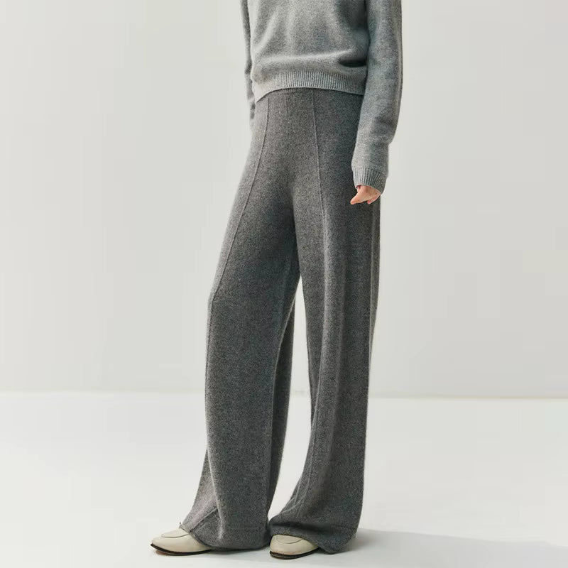 Grey high-waisted wide leg knitted trousers with a center seam paired with a matching grey sweater.