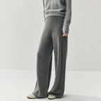 Grey high-waisted wide leg knitted trousers with a center seam paired with a matching grey sweater.